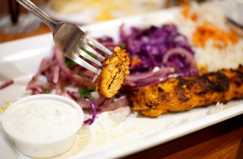 piece of chicken adana kebob on a fork 